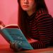 woman in striped long sleeve shirt holding a book